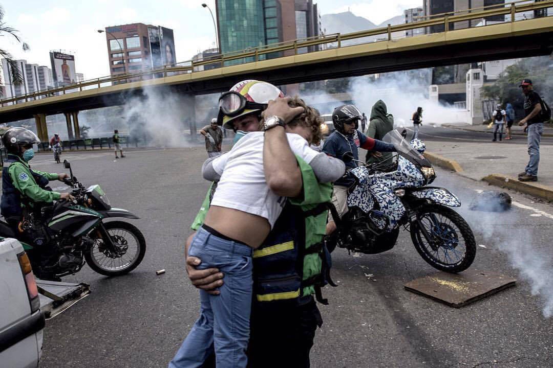 A man with a child holds in it hands, during Venezuela demonstrations.