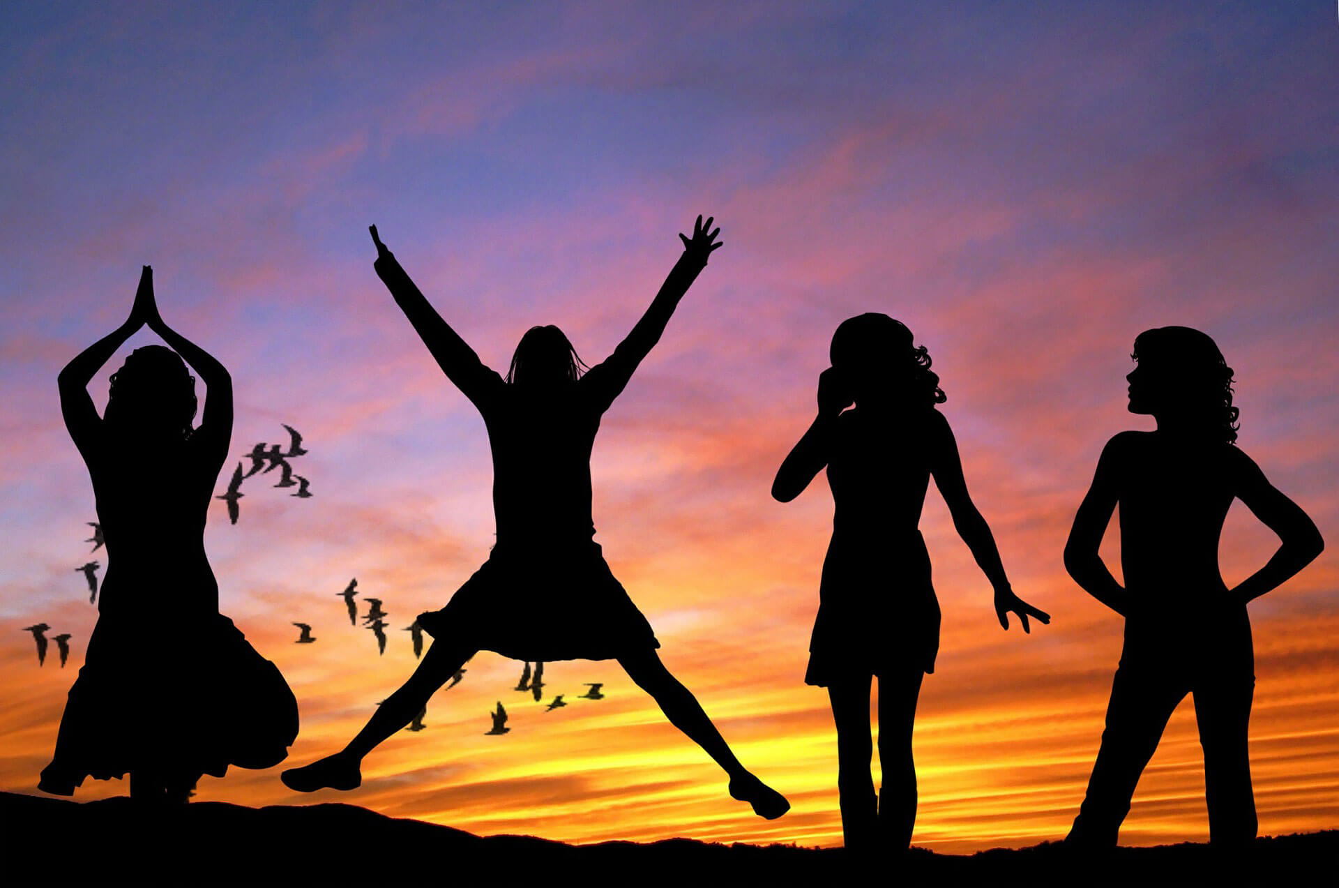 Silhouette of girls and birds at sunset.