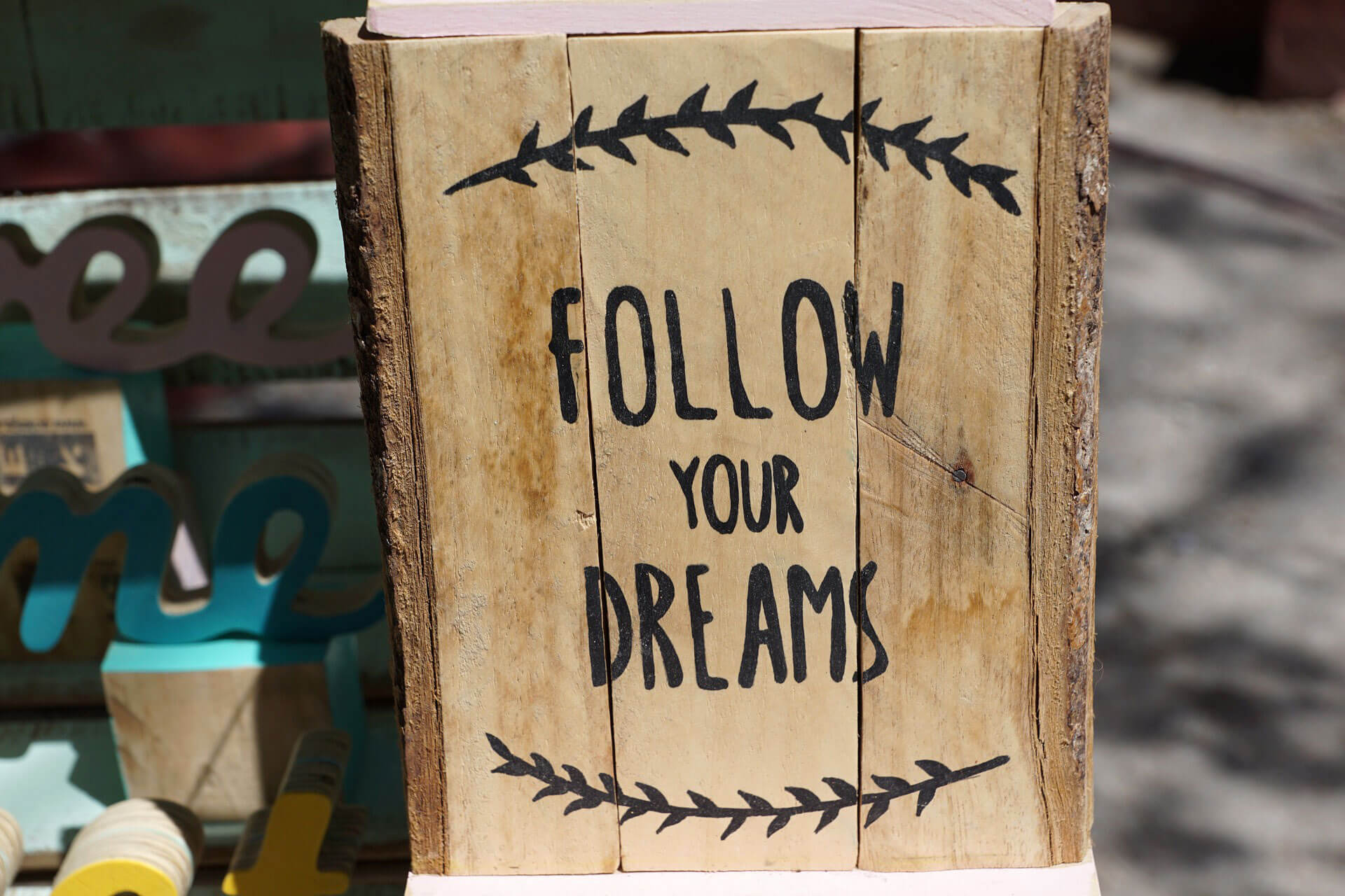 Bloco de madeira com a frase "Follow your Dreams"