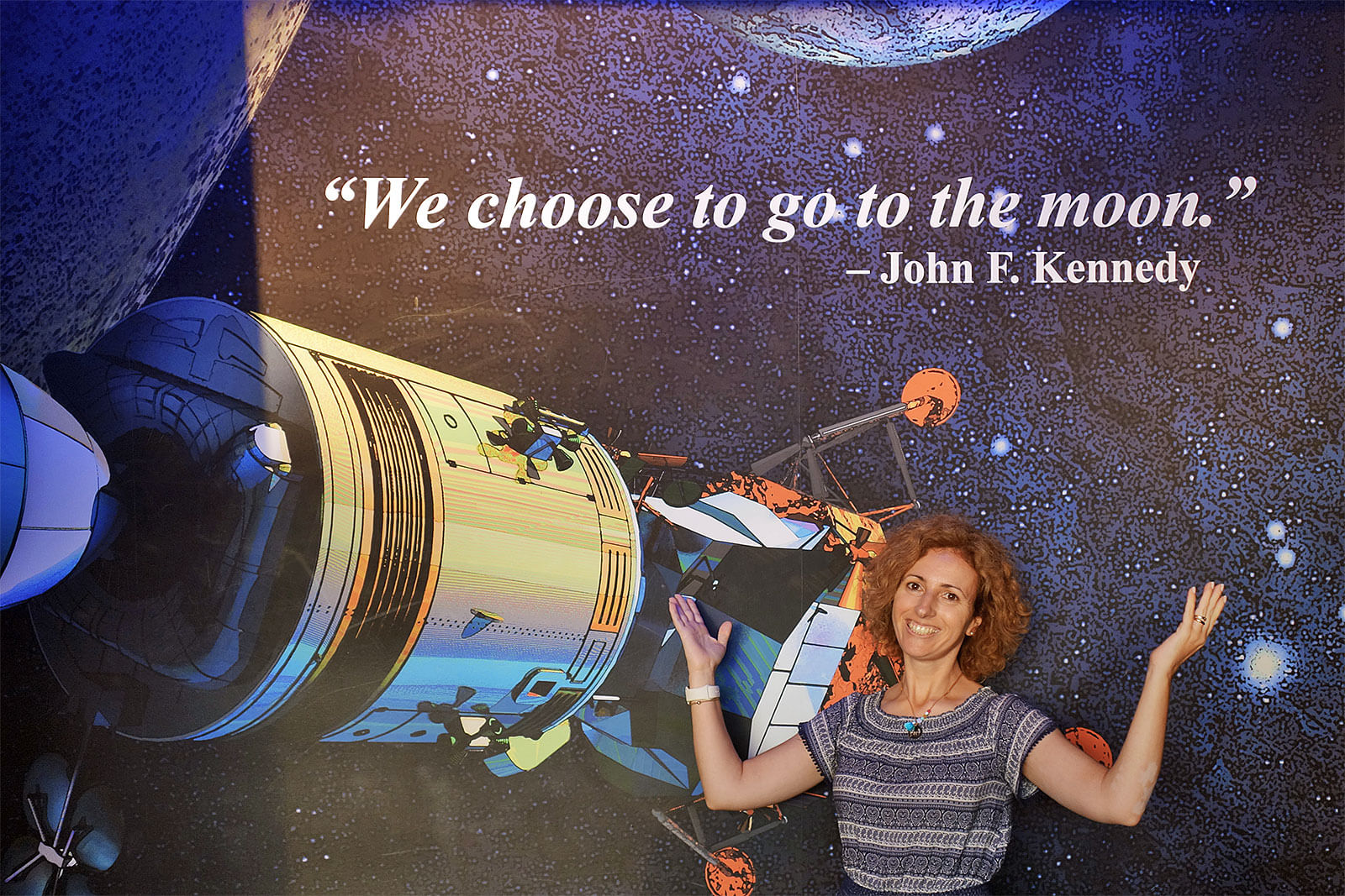 Rita Aleluia junto a placard com satéllite no centro Kennedy, nos Estados Unidos da América.