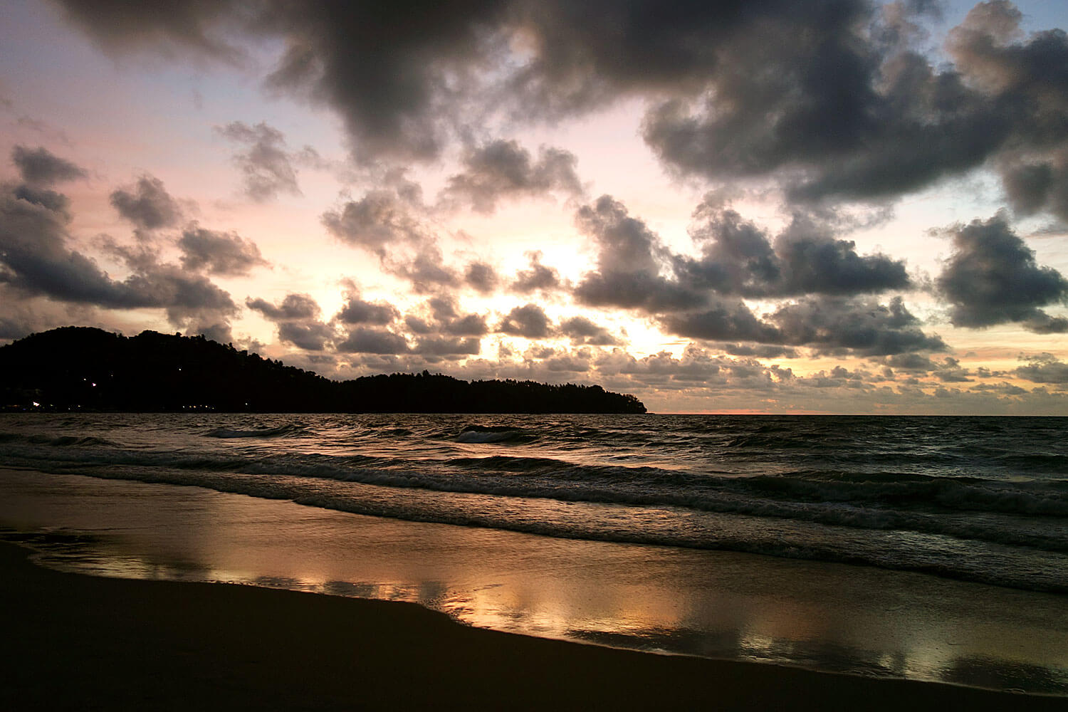 Mar junto a uma praia com pôr-do-sol