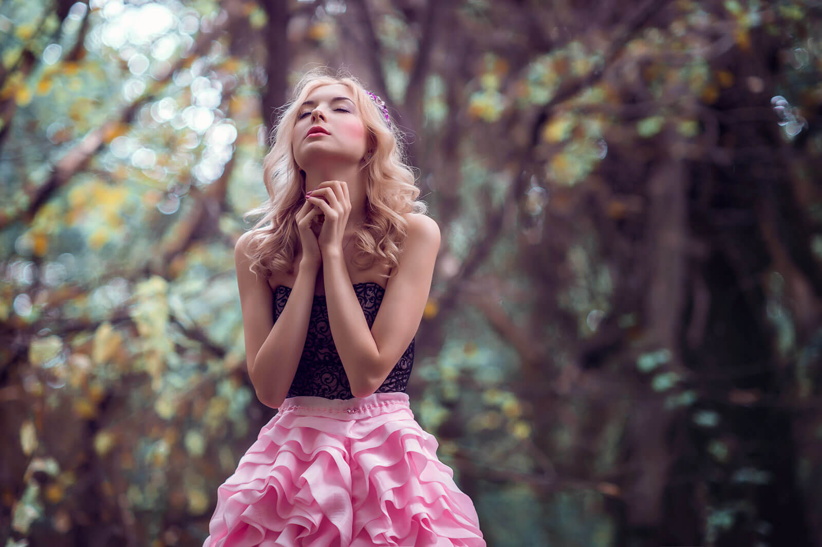 Rapariga de vestido cor-de-rosa numa floresta.